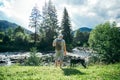 Young strong man stays near mountains river with dog and looking for the view Royalty Free Stock Photo