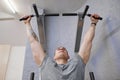 Young strong muscular man in gym, male exercising, doing pull ups Royalty Free Stock Photo