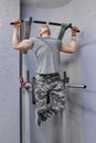 Young strong muscular man in gym, male exercising, doing pull ups Royalty Free Stock Photo