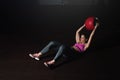Young strong sweaty fit muscular girl with big muscles doing sit ups with medicine ball for abdominal muscles or abs hard workout Royalty Free Stock Photo