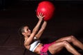 Young strong sweaty fit muscular girl with big muscles doing sit ups with medicine ball for abdominal muscles or abs hard workout Royalty Free Stock Photo