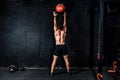 Young strong sweaty focused fit muscular man with big muscles doing throwing medicine ball up on the wall for training hard core w Royalty Free Stock Photo