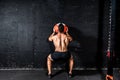 Young strong sweaty focused fit muscular man with big muscles doing throwing medicine ball up on the wall for training hard core w Royalty Free Stock Photo