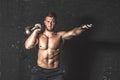 Young strong sweaty focused fit muscular man with big muscles holding heavy kettle bell for training hard core workout in the gym Royalty Free Stock Photo