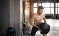 Young strong fit muscular man doing throwing medicine ball up on the wall for crossfit training hard core workout in gym Royalty Free Stock Photo