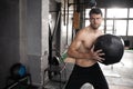 Young strong fit muscular man doing throwing medicine ball up on the wall for crossfit training hard core workout in gym Royalty Free Stock Photo