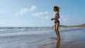 Young strong woman in sportswear doing plyometric exercises on pier. Jump squats, fitness workout outdoors. SLOW MOTION