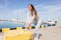 Young strong woman in sportswear doing plyometric exercises on pier.