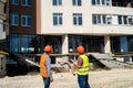 young strong workers in uniform and helmet stand near the finished new house Royalty Free Stock Photo