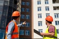 young strong workers in uniform and helmet stand near the finished new house Royalty Free Stock Photo