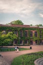 A young student couple walking in front of the beautiful brick facade of Palaestra et Odeum in the university town of Lund Sweden