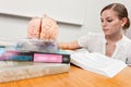 Young student does studies with books and a brain model