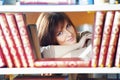 Young student girl at book shelf