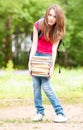 Young student girl holding big pile of heavy books Royalty Free Stock Photo