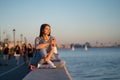 Young student girl with skateboard and drink relax looking at sunset at river bank and enjoy summer