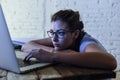 Young student girl studying tired at home laptop computer preparing exam exhausted and frustrated feeling stress Royalty Free Stock Photo