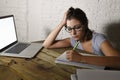 Young student girl studying tired at home laptop computer preparing exam exhausted and frustrated feeling stress Royalty Free Stock Photo