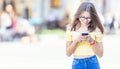 Young student girl texting on her smartphone and smiling Royalty Free Stock Photo