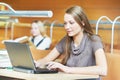 Young student girl working with laptop in library