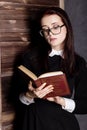 Young student in glasses with books in hand, mysteriously looking at the camera