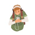 Young student in headphones listening to music using mobile phone. Happy teenager holding smartphone and looking at