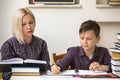 Young student learns at home with a his mom tutor. Helping. Royalty Free Stock Photo