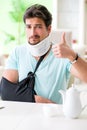 The young student man with neck and hand injury at home Royalty Free Stock Photo