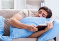 The young student man preparing for college exams in bed with bo Royalty Free Stock Photo