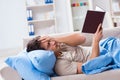 The young student man preparing for college exams in bed with book Royalty Free Stock Photo