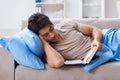 The young student man preparing for college exams in bed with book Royalty Free Stock Photo