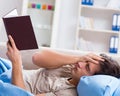 Young student man preparing for college exams in bed with book Royalty Free Stock Photo