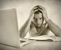 Young student man in stress overwhelmed studying exam with book and computer Royalty Free Stock Photo