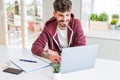 Young student man using computer laptop and notebook with a happy face standing and smiling with a confident smile showing teeth Royalty Free Stock Photo