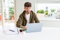 Young student man using computer laptop and notebook with a happy face standing and smiling with a confident smile showing teeth Royalty Free Stock Photo