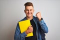 Young student man wearing denim shirt backpack notebook over isolated white background screaming proud and celebrating victory and Royalty Free Stock Photo