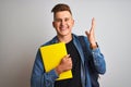 Young student man wearing denim shirt backpack notebook over isolated white background very happy and excited, winner expression Royalty Free Stock Photo