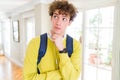 Young student man wearing headphones and backpack with hand on chin thinking about question, pensive expression Royalty Free Stock Photo