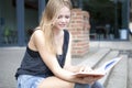 Young student outside reading book and smiling Royalty Free Stock Photo