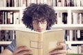 Young student reading book in library Royalty Free Stock Photo