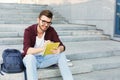 Young student making notes sitting on stairs Royalty Free Stock Photo