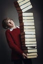 Young student with stack of falling books