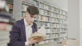 Young student study hard in library. Male university student doing study research in library with books Royalty Free Stock Photo