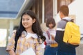 Young student teenager girl high school student carrying schoolbag holding notebooks with friends in background Royalty Free Stock Photo