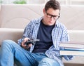 Young student trying to balance studying and playing games Royalty Free Stock Photo