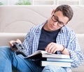 Young student trying to balance studying and playing games Royalty Free Stock Photo