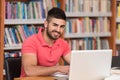 Young Student Using His Laptop In A Library Royalty Free Stock Photo