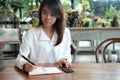 Young student woman holding pen for writing on notebook paper an Royalty Free Stock Photo