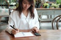 Young student woman holding pen for writing on notebook paper an Royalty Free Stock Photo