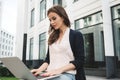 Young student woman sits in city park with modern laptop Royalty Free Stock Photo