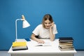 Young student woman in white casual clothes reading the book in library of university or college. Sitting and reading on Royalty Free Stock Photo